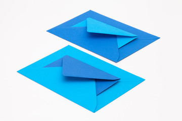 Jigsaw puzzle from big and small blue envelopes on the white table.