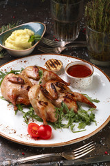 Two quail grills with mashed potatoes and arugula