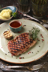 Steak ribay with mashed potatoes and sauce.