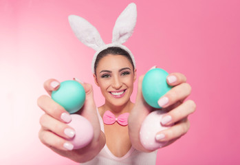 Smiling bunny woman showing a easter  eggs