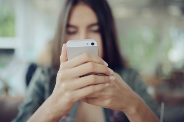 Girl with a phone in a cafe in the summer