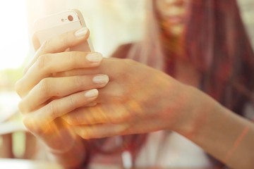 Girl with a phone in a cafe in the summer