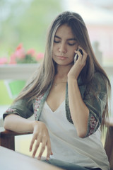 Girl with a phone in a cafe in the summer