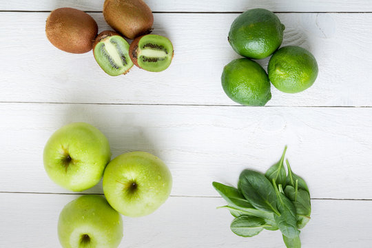 Ingredients for smoothie. Green fruits on white wooden background. Apple, lime, spinach, kiwi. Detox. Healthy food. Top view.