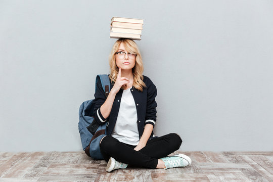 Thinking Young Woman Student Holding Books On Head.