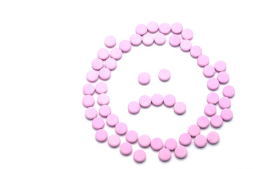 Sad unhappy face of pink pills  on white background. Tablets of drug for asthma treatment