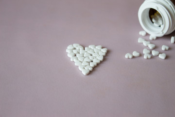 Symbol heart from pills pink background