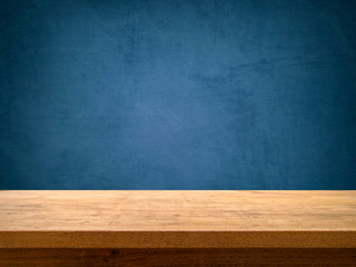 Empty wooden table on blue chalkboard background