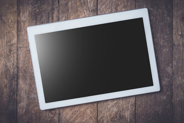 Modern white digital tablet on wooden table. Close up
