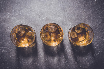 Glasses of whiskey on gray stone background. Close up