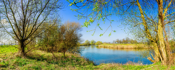 Fototapeta na wymiar Landschaft im Frühling mit Fluss bei strahlendem Sonnenschein
