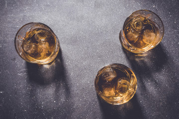 Glasses of whiskey on gray stone background. Close up