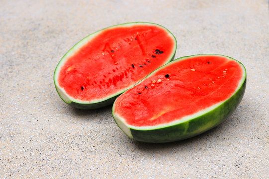 watermelon red fresh half  on polished stone table select focus with shallow depth of field.