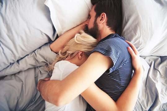 Couple embracing in bed