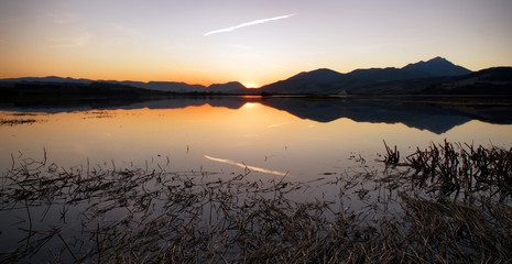 Colorful sunset over lake and mountains