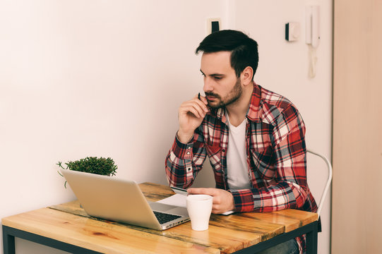 Young Male Student Studying On A Laptop At Home