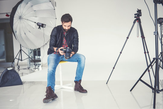 Male photographer reviewing studio photo shoot on digital slr