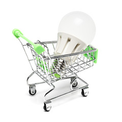 Shopping cart with energy saving light bulb isolated on white background