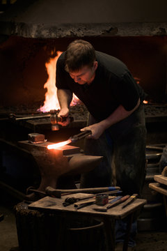 Farrier forging horseshoe on anvil