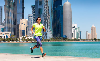 Weibliche Joggerin vor der Skyline von Doha, Katar