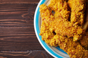 Crispy fried chicken breast on an old rustic wooden background, Close up. With a lot of copy space.
