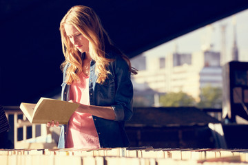 Woman reading at book stall, London, UK