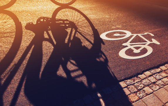 Fototapeta Shadow of unrecognizable cyclist on bicycle lane