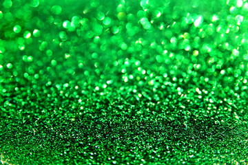 green glitter blurred defocused texture. Christmas abstract sparkle background for party invitation and greeting cards.
