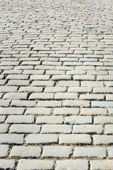 Tiled with paving stone bricks path's fragment as an abstract background