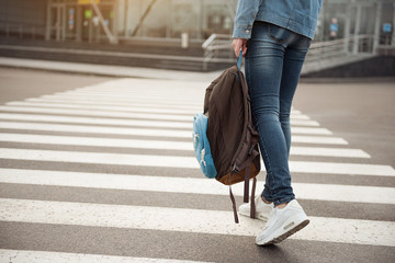 Young tourist stepping across route