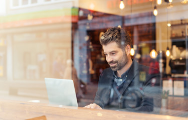 man working on a digital project in a cafe