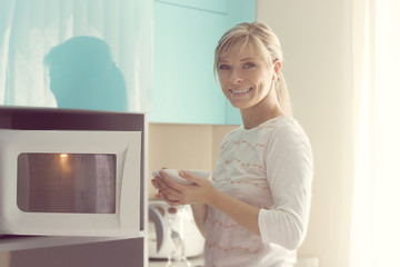 Fototapeta na wymiar Pretty Woman at home using microwave oven