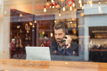 man working on a digital project in a cafe