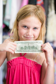 Portrait of girl holding dollar bill