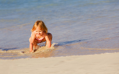 happy little girl play with water at beach