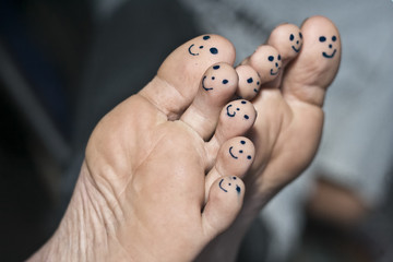 smiley face drawn on human toes.