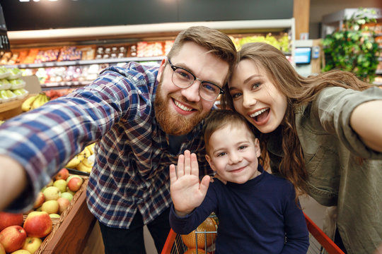 Happy young family posing in supermarket