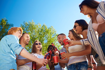 Cheerful buddies toasting with drinks at party