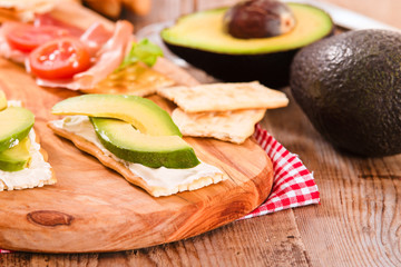 Crackers with ham and avocado. 