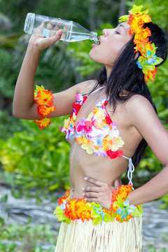 Hawaii Hula woman dancer drinks water from a bottle