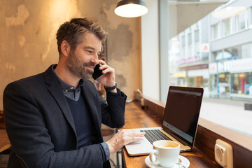 man working with laptop and smartphone