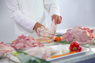 A chef is preparing meat for dinner. He is going to make a chicken dish.