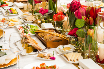 Served table with cold appetizers and decorated with flowers