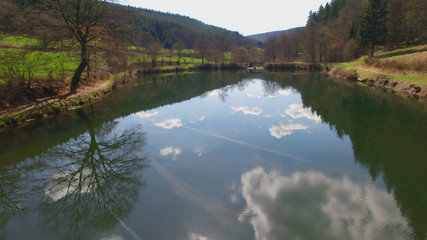 The water surface of the Eutersee is reflecting the clouds.  The Eutersee is a little lake in south Hessia, Germany.
