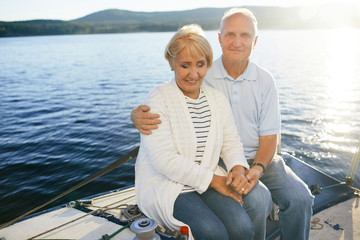 Mature man embracing his wife while traveling by yacht