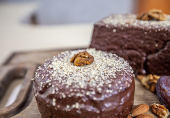 A beautiful chocolate cake with coconut flour and a walnut on top. 