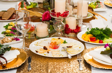 Plates with cheese sliced on a serving table