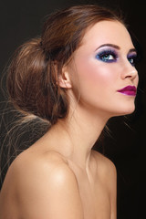 Fototapeta premium Young beautiful woman with colorful make-up and stylish hair bun