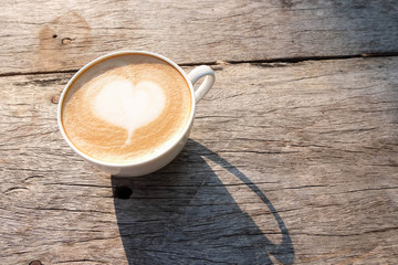 A cup of coffee on wooden table in the garden background