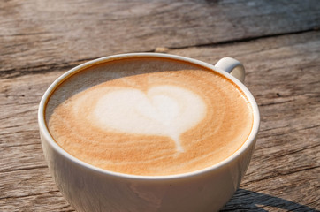A cup of coffee on wooden table in the garden background